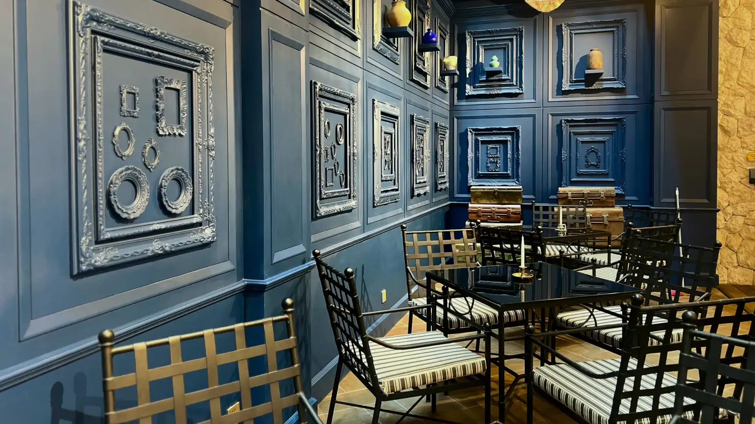 Deep blue paneled wall facility with empty frames and seating